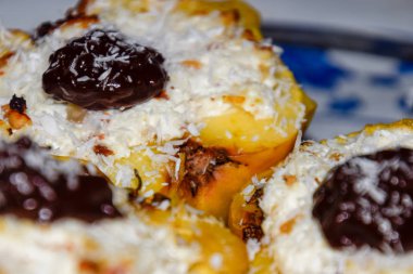 Elma süzme peynir ile pişmiş ve çikolata ve hindistan cevizi cips ile dekore.