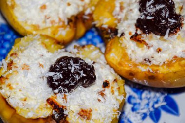 Elma süzme peynir ile pişmiş ve çikolata ve hindistan cevizi cips ile dekore.