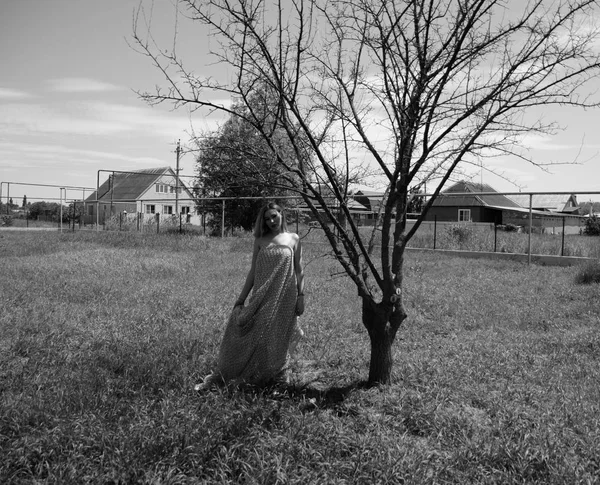 Foto preto e branco, menina no jardim em um prado em um vestido . — Fotografia de Stock