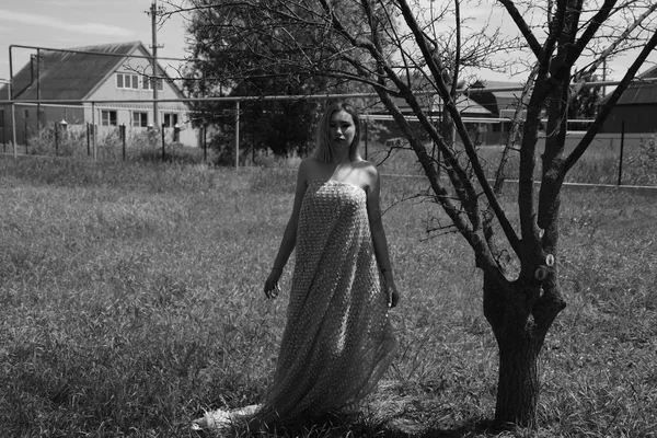 Foto en blanco y negro, chica en el jardín en un prado en un vestido . — Foto de Stock