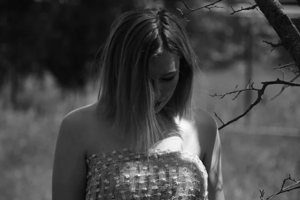 Foto en blanco y negro, chica en el jardín en un prado en un vestido . — Foto de Stock