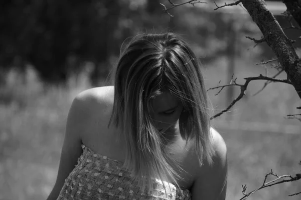 Musta ja valkoinen kuva, tyttö puutarhassa niityllä mekko . — kuvapankkivalokuva