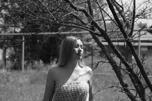 Foto en blanco y negro, chica en el jardín en un prado en un vestido . — Foto de Stock