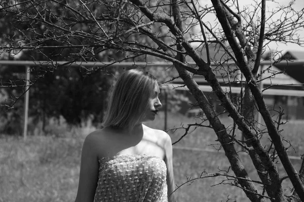 Black and white photo, girl in the garden on a meadow in a dress. — Stock Photo, Image