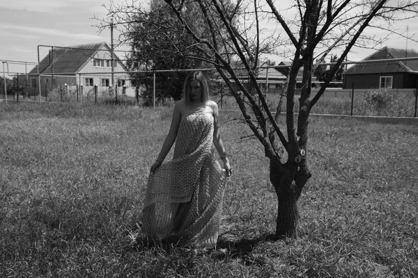 Foto en blanco y negro, chica en el jardín en un prado en un vestido . —  Fotos de Stock