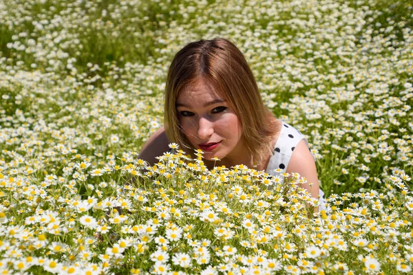 Polka noktaları ile beyaz elbiseli bir kadın papatyalar ile bir glade üzerindedir. Çiçek açan papatyalar — Stok fotoğraf