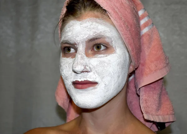 Cosmetic white face mask of toothpaste. Woman in white cosmetic mask