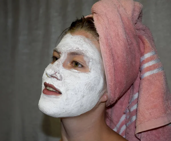 Cosmetic white face mask of toothpaste. Woman in white cosmetic mask