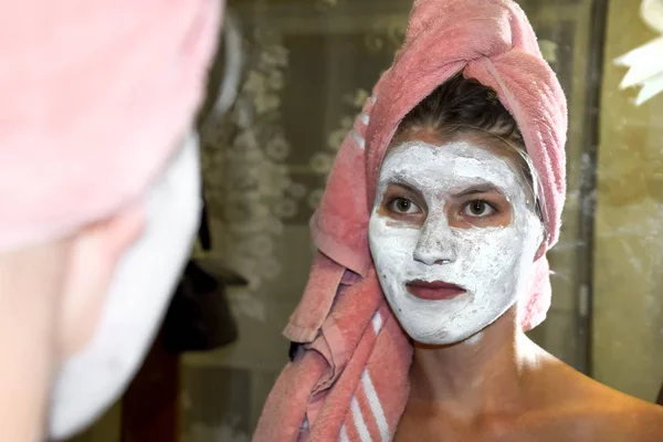 Cosmetic white face mask of toothpaste. Woman in white cosmetic mask