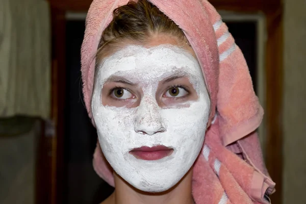Cosmetic white face mask of toothpaste. Woman in white cosmetic mask