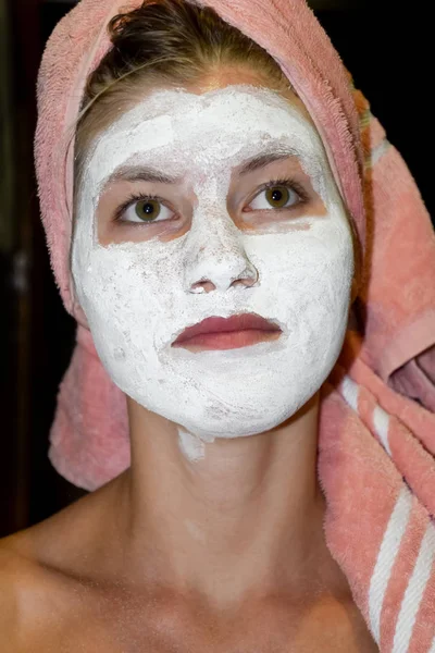 Cosmetic white face mask of toothpaste. Woman in white cosmetic mask