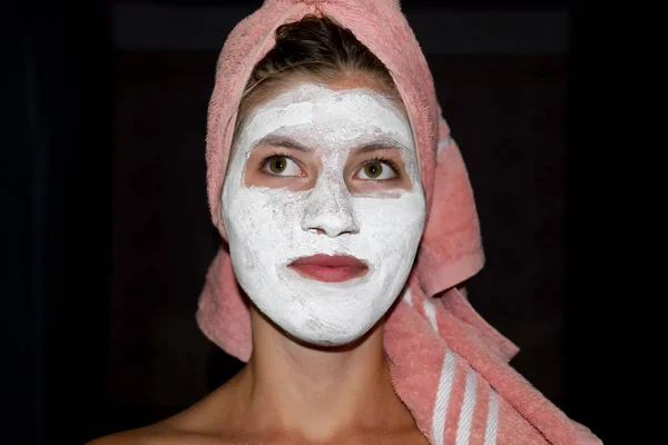 Cosmetic white face mask of toothpaste. Woman in white cosmetic mask