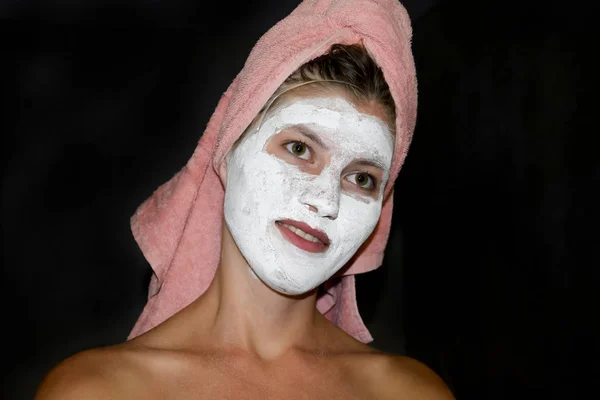 Cosmetic white face mask of toothpaste. Woman in white cosmetic mask