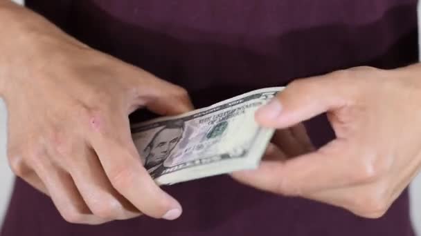 Чоловік тримає, перевертаючись, в руках пачки доларів — стокове відео
