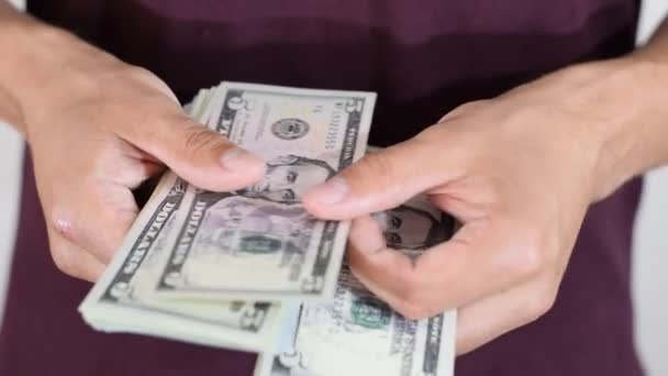 O homem relata casualmente um maço de dólares nas mãos. Dólares — Vídeo de Stock