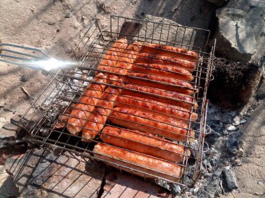Bir ateşe kızarmış kupaty tavuk. Barbekü