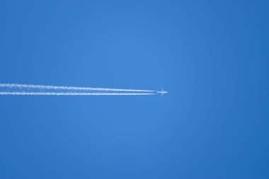 Mavi gökyüzünde bir uçaktan yoğuşma izi