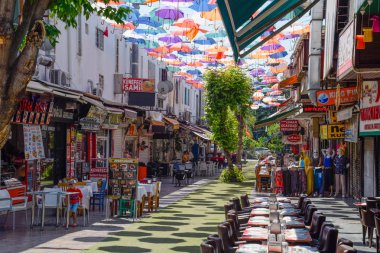 Kaleiçi'nde binalar arasında şemsiyeler asılı.