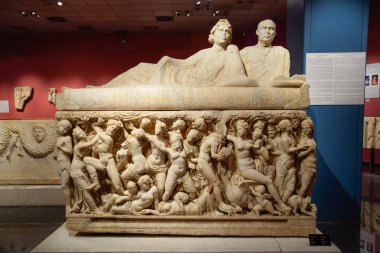 Çıplak insanların antika figürlerinin görüntüsü ile mermer lahit, lahitin kabartmaları üzerine antika sahneler.