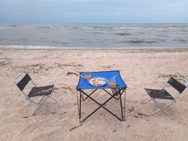 Lunch by the sea, tourist folding furniture, chairs and a table.