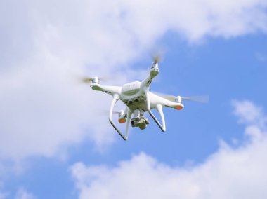 Uçuş quadrocopters beyaz bulutlar ile mavi gökyüzüne karşı
