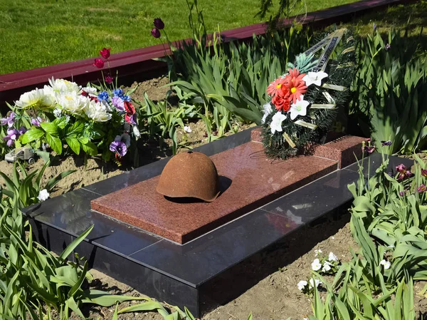 The old soldier's protective helmet. The helmet with a hole. The steel helmet on the monument — Stock Photo, Image