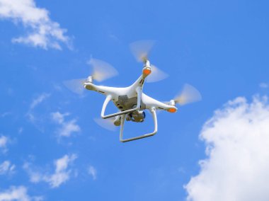 İle DJI indeks işlem Phantom 4 uçuş robot. Quadrocopter beyaz bulutlar ile mavi gökyüzüne karşı. Gökyüzünde helikopter uçuş.
