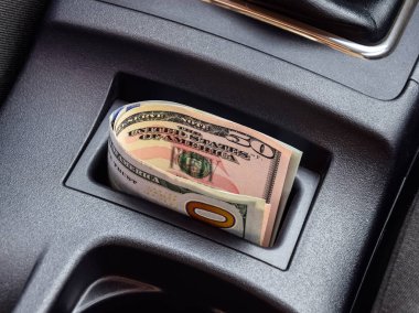 Birkaç banknot Amerikan Doları arabanın Merkezi Konsol niş içinde yalan. Para arabada