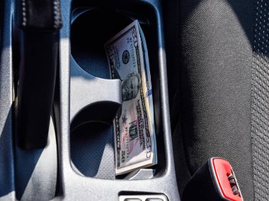 Birkaç banknot Amerikan Doları arabanın Merkezi Konsol niş içinde yalan. Para arabada