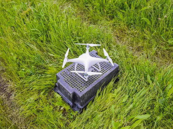 Квадрокоптеры на пластиковой коробке в траве — стоковое фото