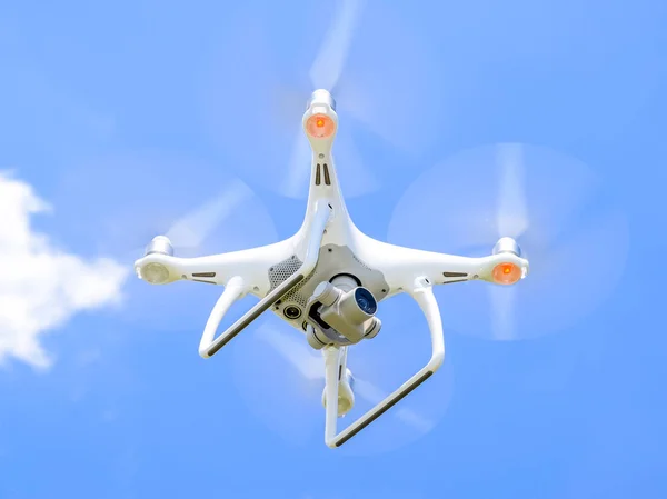 Drönare Dji Phantom 4 under flygning. Quadrocopter mot blå himmel med vita moln. Flyg av copter i himlen. — Stockfoto