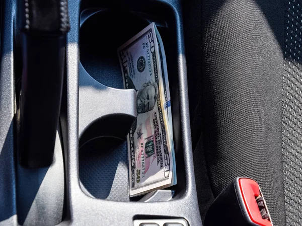 Birkaç banknot Amerikan Doları arabanın Merkezi Konsol niş içinde yalan. Para arabada