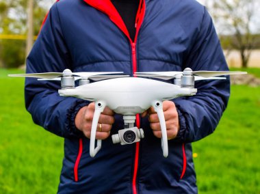 Quadrocopter onun elinde olan bir adam. Beyaz bir dron p ediliyor