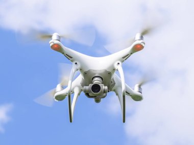 Uçuş quadrocopters beyaz bulutlar ile mavi gökyüzüne karşı