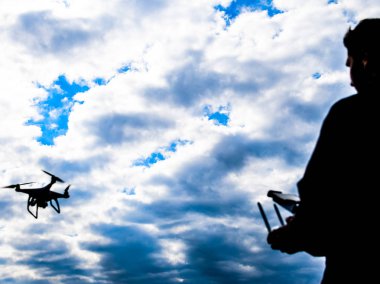 Bir adam elinde bir uzaktan kumanda ile. Gökyüzüne karşı drone uçuş kontrol. Hayalet.