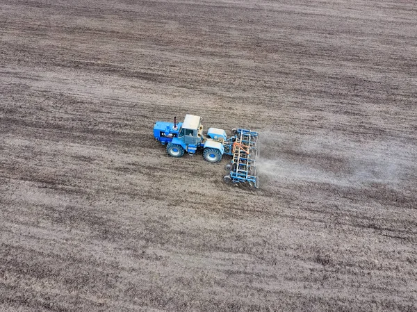 Budidaya tanah untuk menabur sereal. Traktor membajak tanah di lapangan — Stok Foto