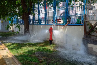 Açık ateş musluğu, bir yangın musluğundan su akar.