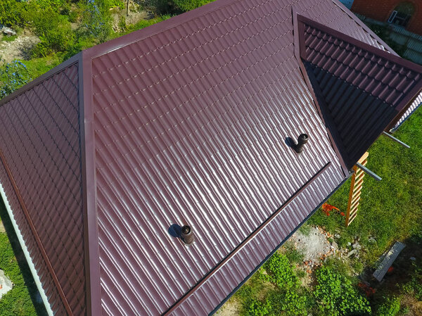 Вид сверху на крышу дома. Крыша из гофрированного листа. Крыша металлического профиля волнистой формы
