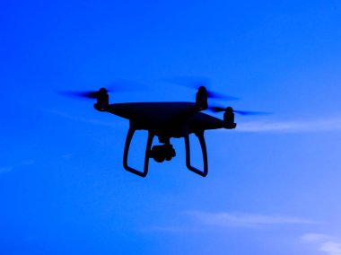 Quadrocopters siluet güneşin arka planı. Akşam gökyüzünde uçan uçaklar