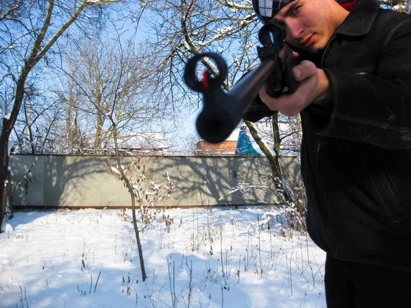 겨울 공원에서 공기 소총을 가진 남자. — 스톡 사진