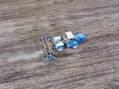 Traktör alan pulluklar. Ekim altında toprak sahada gevşetti.