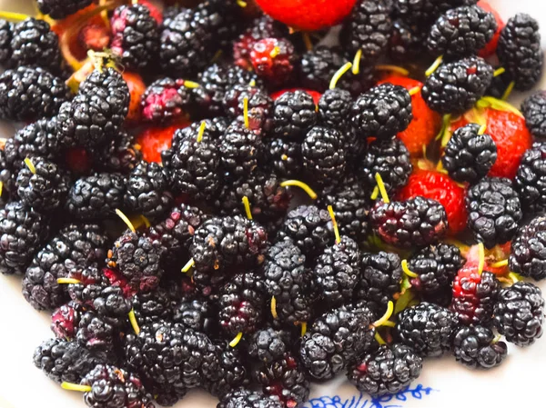 Mulberry z truskawkami na talerzu. Makro owoc — Zdjęcie stockowe