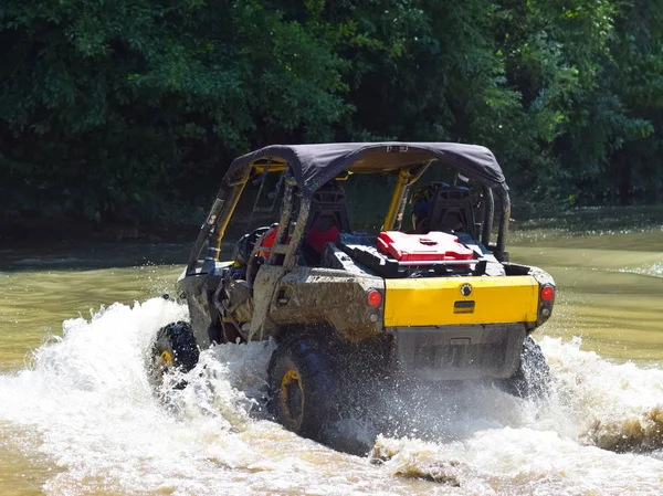 El hombre en el ATV cruza un arroyo — Foto de Stock