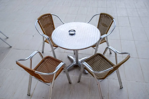 Μεταλλικά τραπέζια και καρέκλες με ψάθινα καθίσματα σε υπαίθριο καφέ. — Φωτογραφία Αρχείου