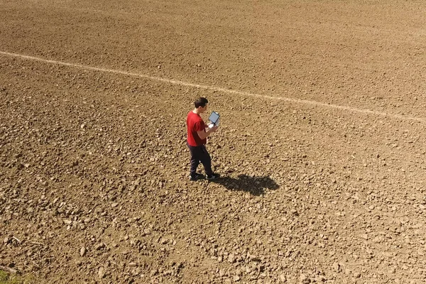 Um homem com um controlo remoto do drone. Um homem no campo controla o drone. . — Fotografia de Stock