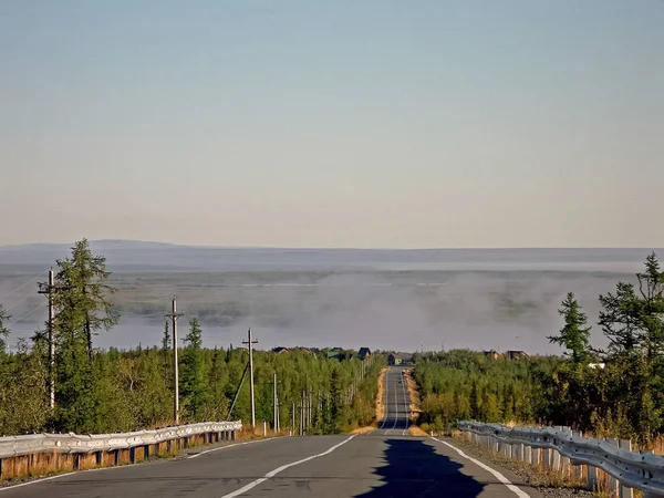 Camino de asfalto al pueblo de la taiga . — Foto de Stock