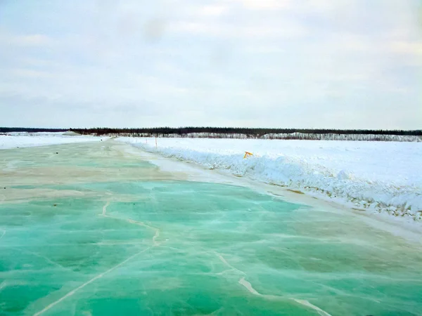 Der gefrorene Fluss taut auf. Algen unter dem Eis lackierten es grün. — Stockfoto