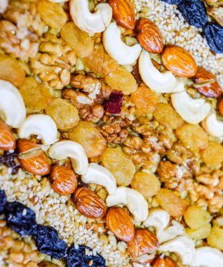 Kozinaki deli ve tohum ile kaplı. Badem, kaju fıstığı ve kuru üzüm.