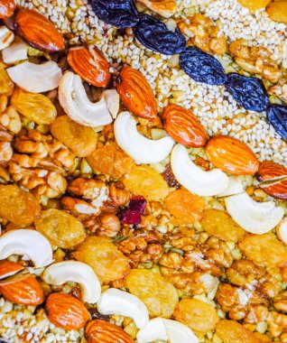 Kozinaki deli ve tohum ile kaplı. Badem, kaju fıstığı ve kuru üzüm.