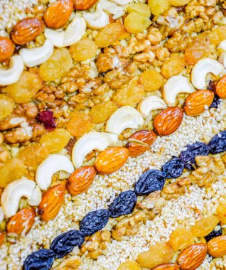 Kozinaki deli ve tohum ile kaplı. Badem, kaju fıstığı ve kuru üzüm.